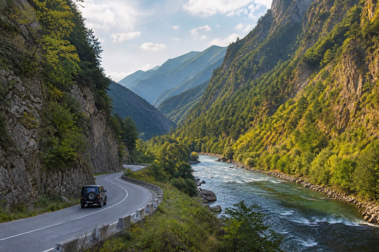 A winding road following a river into a mountain valley